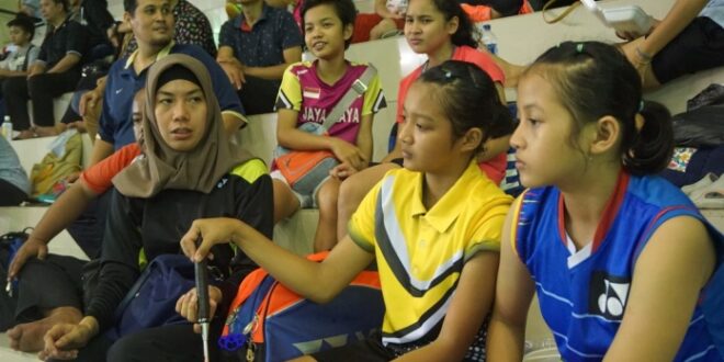 Adriyanti Firdasari berhijab saat mendampingi anak asuhnya di lapangan