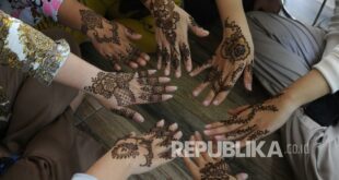 pengguna jasa menunjukan hasil lukis dengan henna di tangannya