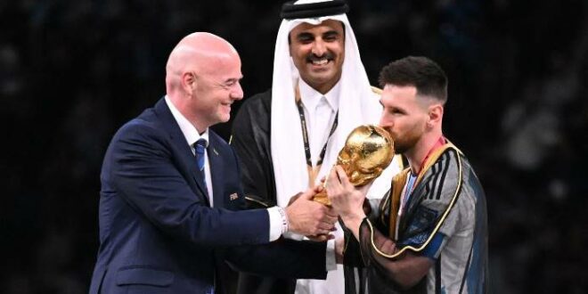 Messi mengenakan jubah tradisional Arab Bisht saat menerima tropi Piala Dunia dari Presiden FIFA Gianni Infantino